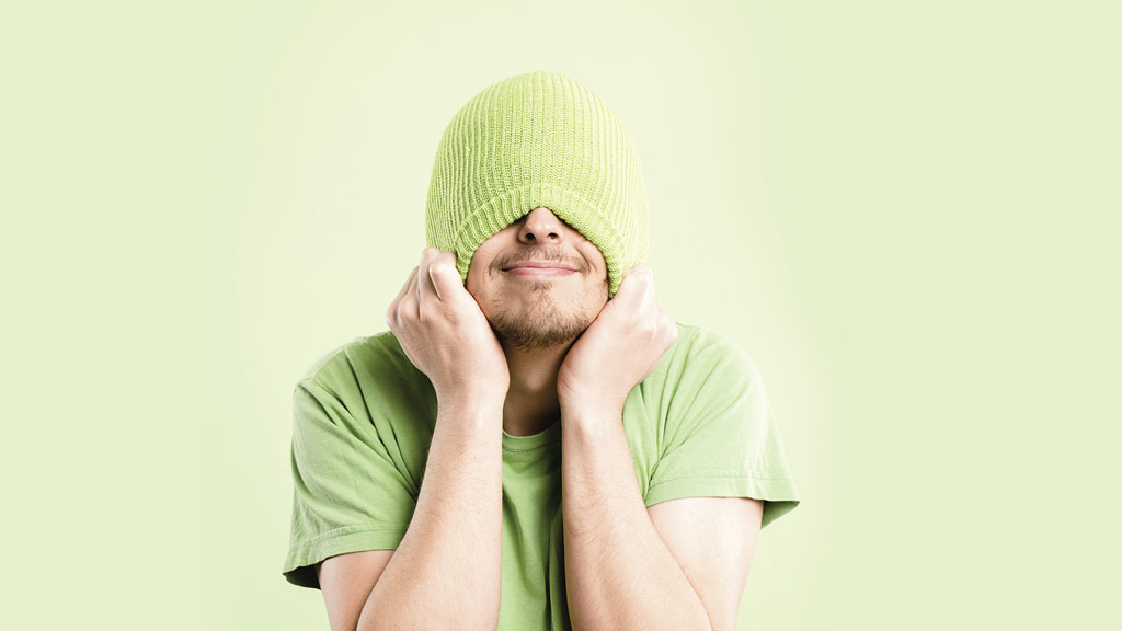 embarassed man pulling beanie over head