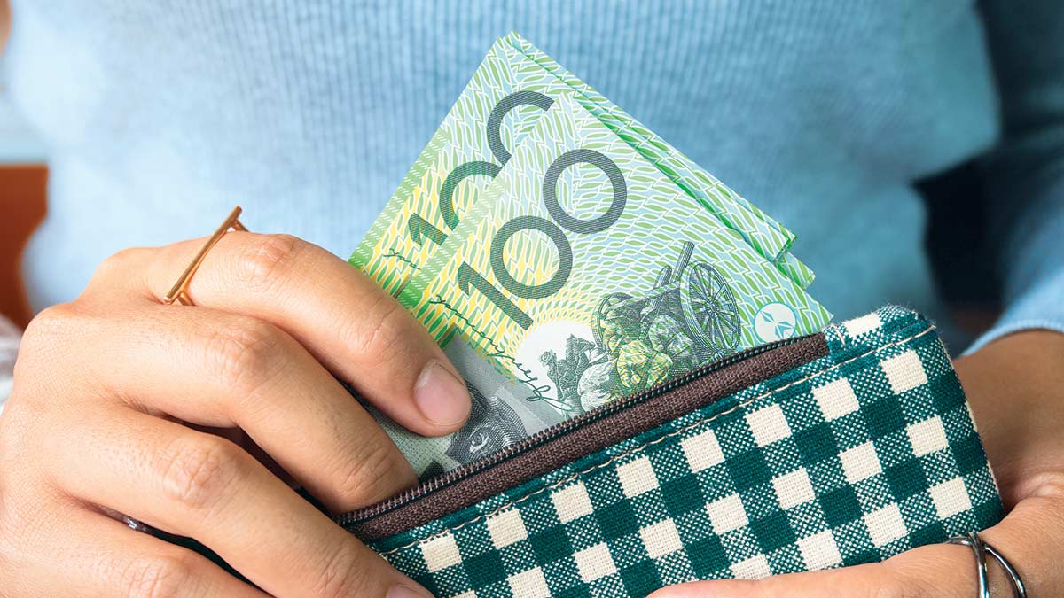 person taking hundred dollar bills out of purse