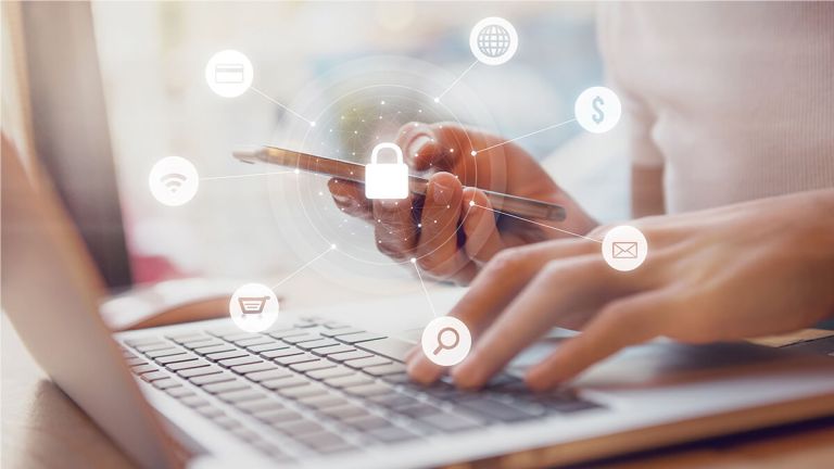 Person using a smartphone and laptop with white graphics showing cyber security network of connected devices and personal data security