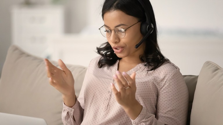 Woman using headset to speak on a laptop