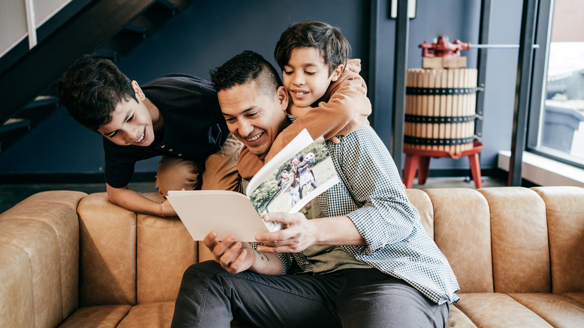 Father and sons looking at a photo book
