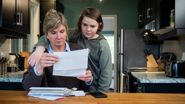woman and child looking at bills