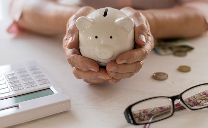senior_persons_hands_holding_a_piggy_bank
