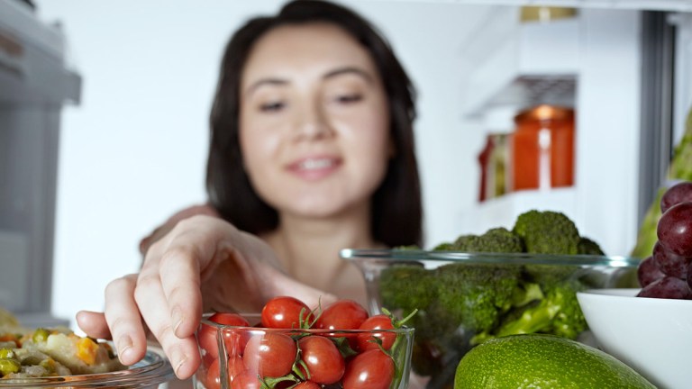 person taking cherry tomatoes out of the fridge