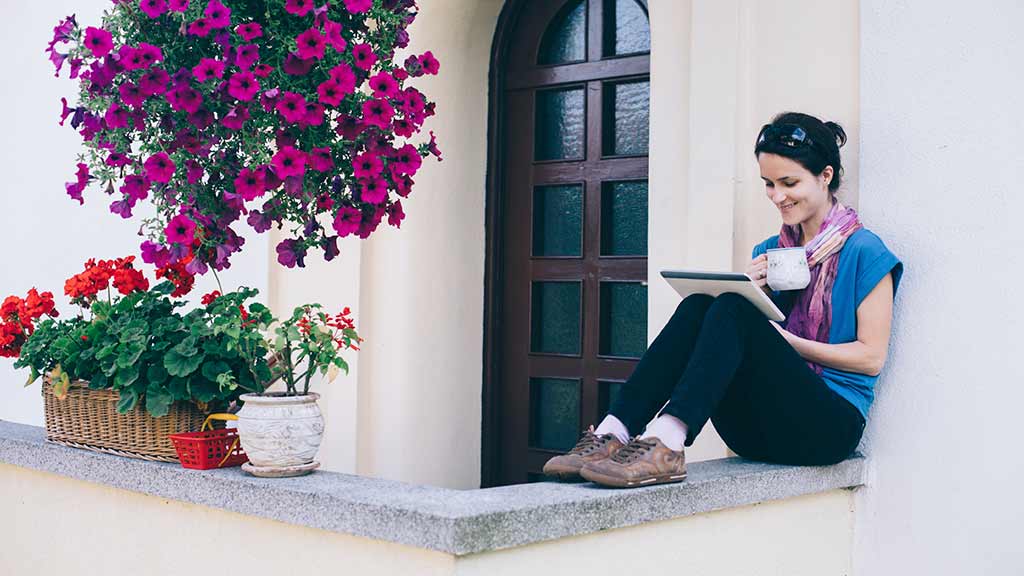 woman using tablet outside on balcony