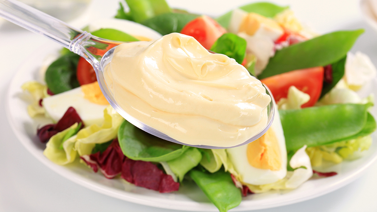 spooning_mayonnaise_onto_vegetable_salad