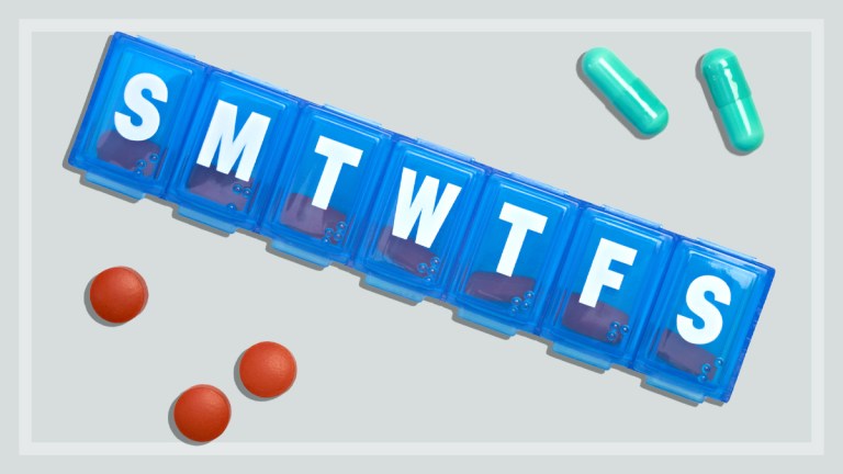 blue 7-day pill box on a grey background with red and green pills