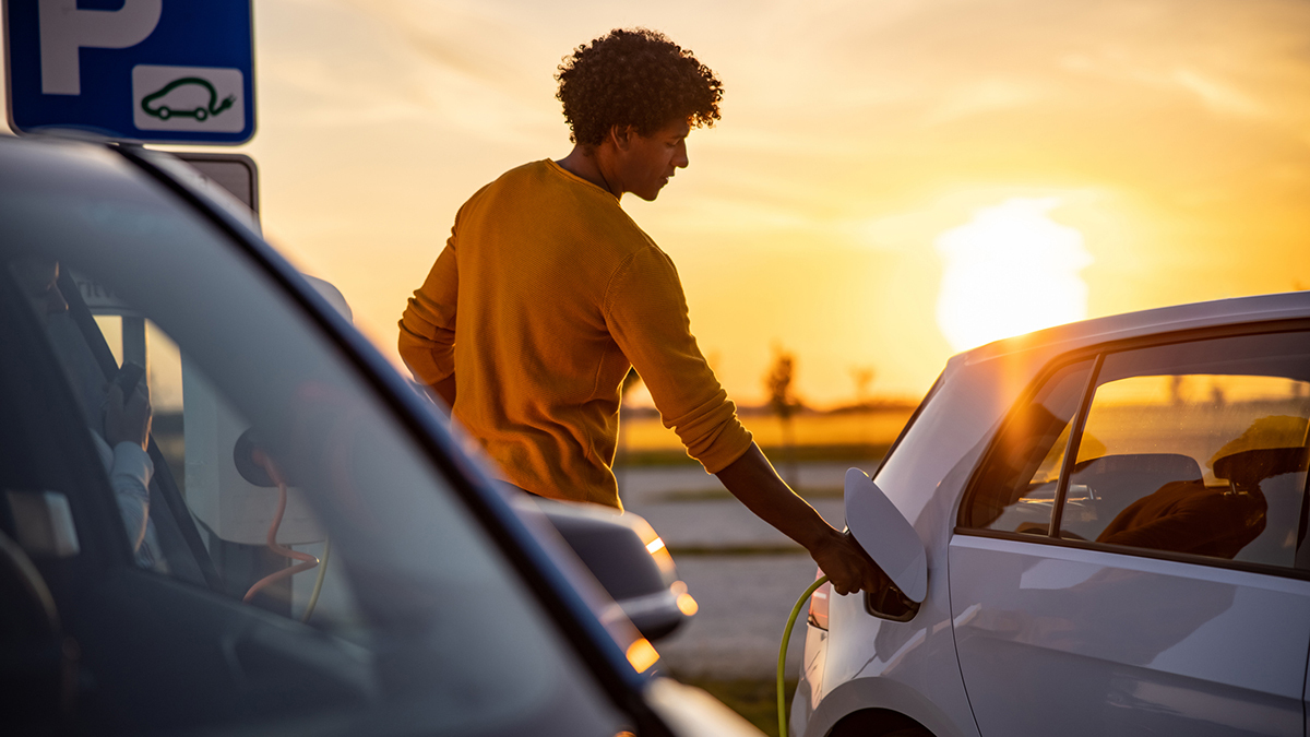 person_charging_electric_vehicle_in_parking_lot