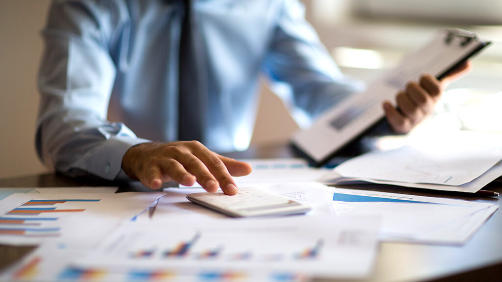 man looking at documents and graphs