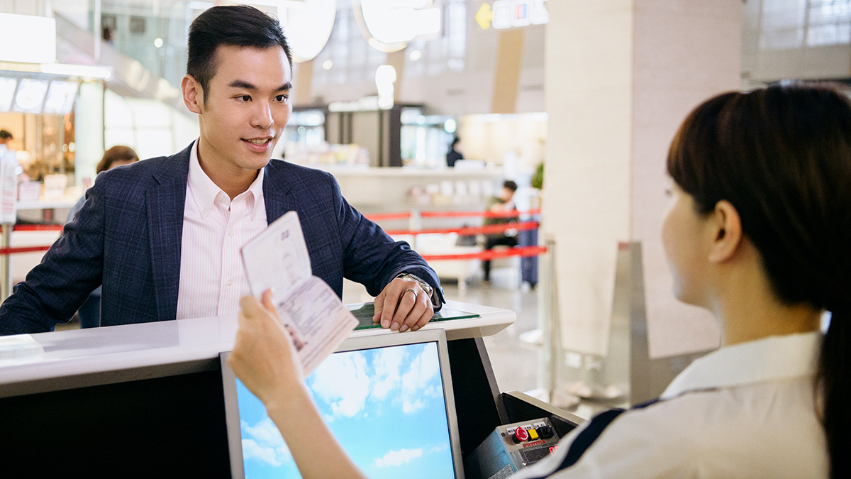 person_at_airline_check-in_counter_having_passport_checked (1)