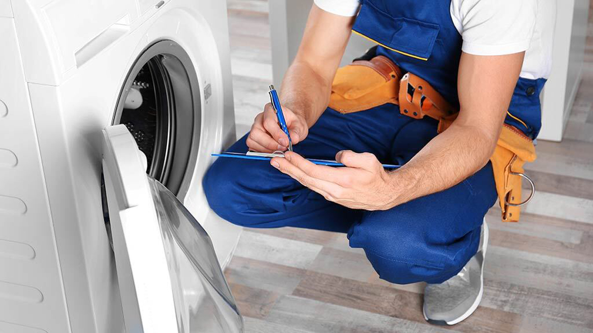 repairman looking at a washing machine
