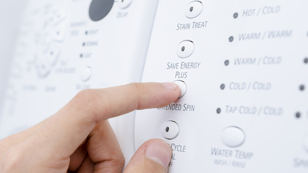 person setting an energy saving program on a washing machine