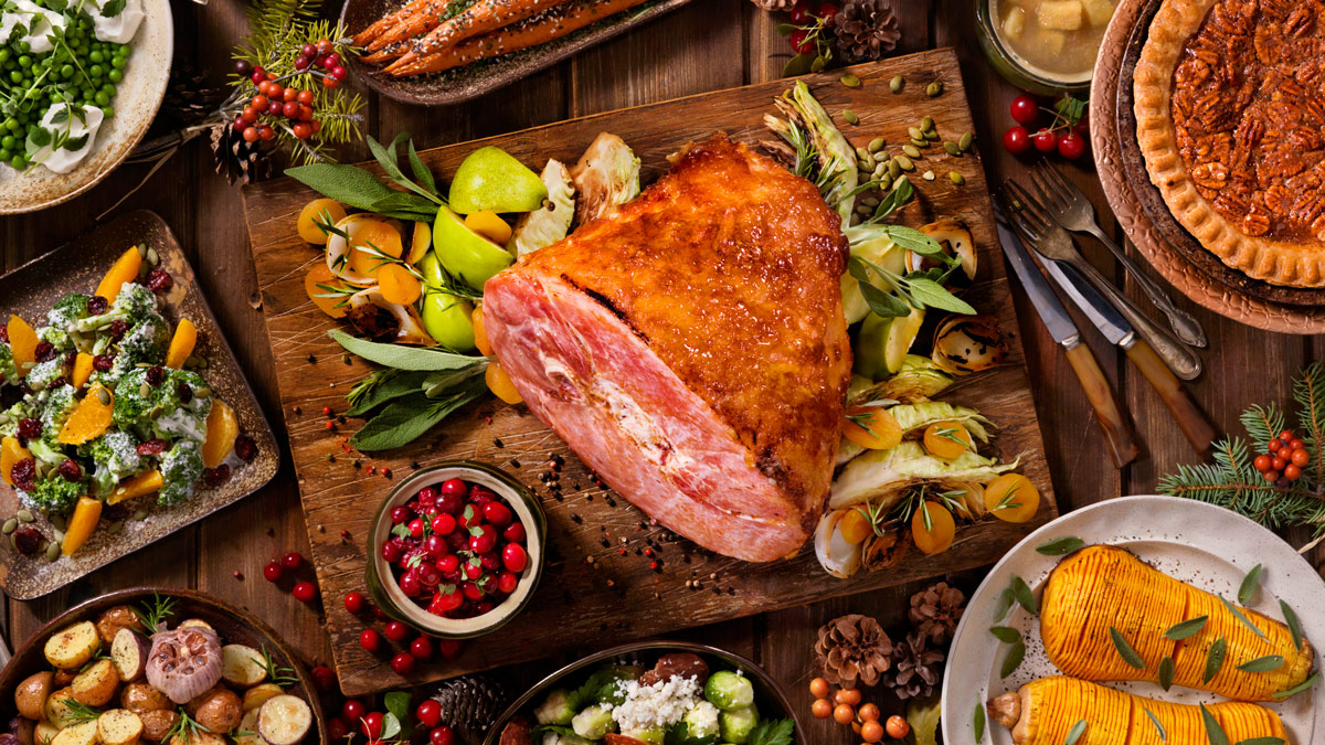 christmas ham on a table with festive side dishes