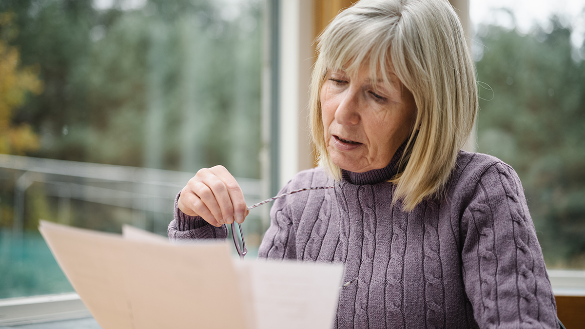 worried senior person looking at energy bill