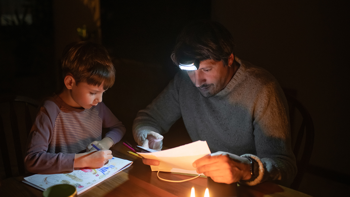 father and son at kitchen table in blackout no power