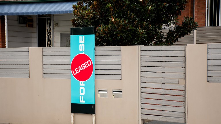 for lease sign with leased sticker in front of an australian rental home