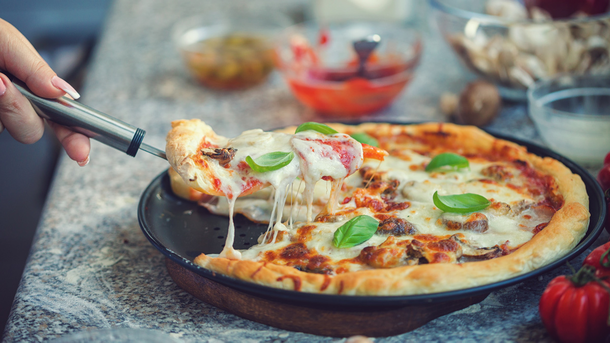 homemade pizza being sliced