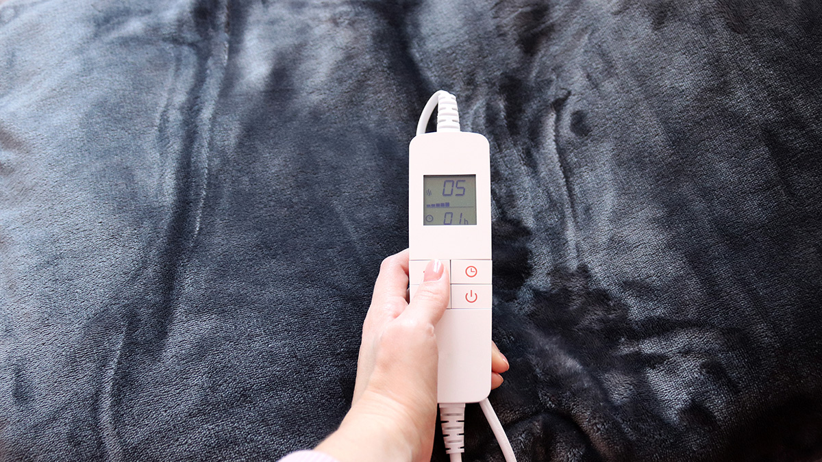 person adjusting controller of heated throw