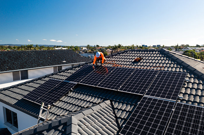 person installing solar panels on a house